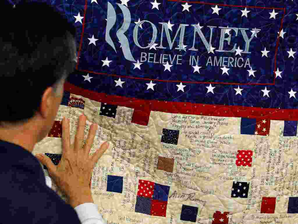 Mitt Romney membaca pesan yang tertulis di sebuah selimut yang dirajut oleh para pendukungnya di Tampa, Florida (Reuters).