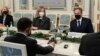 Ukrainian President Volodymyr Zelenskiy, left with back to camera, sits at a table with U.S. Secretary of State Antony Blinken, right, during their meeting at the Presidential Office in Kyiv, Ukraine, Jan. 19, 2022. 