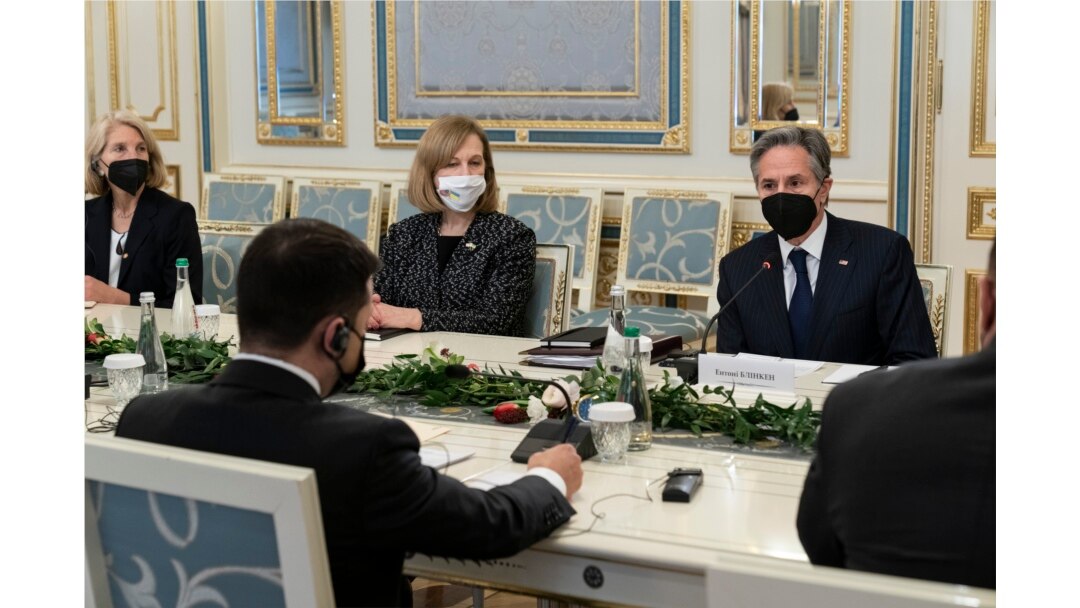Presiden Ukraina Volodymyr Zelenskiy, kiri dengan punggung menghadap kamera, duduk di meja dengan Menteri Luar Negeri AS Antony Blinken, kanan, selama pertemuan mereka di Kantor Kepresidenan di Kyiv, Ukraina, 19 Januari 2022. (Foto: AP)