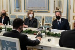 Presiden Ukraina Volodymyr Zelenskiy, kiri dengan punggung menghadap kamera, duduk di meja dengan Menteri Luar Negeri AS Antony Blinken, kanan, selama pertemuan mereka di Kantor Kepresidenan di Kyiv, Ukraina, 19 Januari 2022. (Foto: AP)