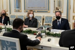 Presiden Ukraina Volodymyr Zelenskiy, duduk di meja dengan Menteri Luar Negeri AS Antony Blinken, kanan, selama pertemuan mereka di Kantor Kepresidenan di Kyiv, Ukraina, 19 Januari 2022. (Foto: AP)
