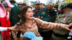 FILE - Tep Vanny of Boeung Kak lake is blocked by riot police officers during a protest rally near the prime minister's residence in Phnom Penh, Cambodia, July 2, 2013. 