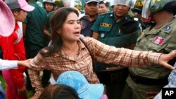 FILE - Tep Vanny of Boeung Kak Lake is blocked by riot police during a protest rally near the prime minister's residence in Phnom Penh, Cambodia, July 2, 2013. 