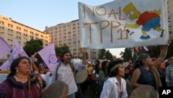 Protesters opposed to the signing of the Trans-Pacific Partnership, TPP, stage a demonstration outside La Moneda presidential palace, in Santiago, Chile, March 7, 2018.