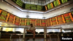 A man rests inside a stock exchange in Kuala Lumpur, Dec. 19, 2013.