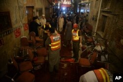 Pakistani rescue volunteers visit at a site of blast in Peshawar, Pakistan, July 10, 2018.