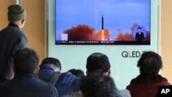 人们在韩国首尔火车站观看朝鲜发射导弹的电视图像。（2017年11月21日）