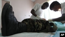 In this Oct. 28, 2010 photo, a doctor and a nurse perform a circumcision procedure on a Zimbabwean soldier at a local clinic in Harare, Zimbabwe. The U.S. Agency for International Development is leading a war on AIDS that may help save hundreds of thousan