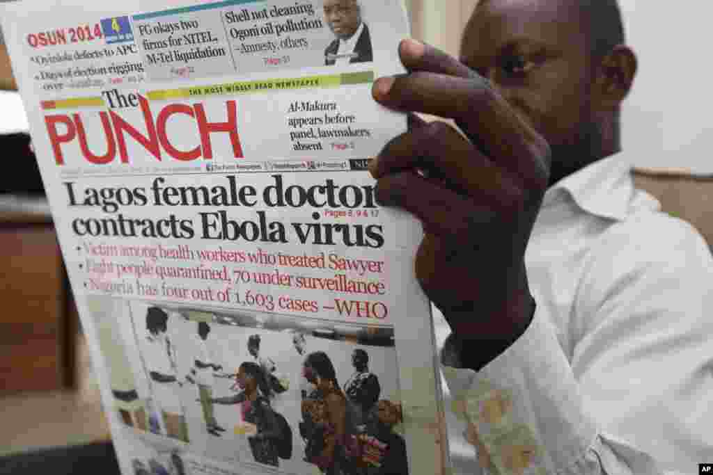 A man reads a local newspaper with headline news about a Lagos female doctor who contracted Ebola, in Lagos, Nigeria, Aug. 5, 2014.