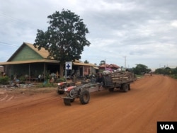 A villager drives a tractor past a private health clinic in Kampong Thom province’s Krayea commune, where children diagnosed with dengue fever stay for treatment, June 2019. (Sun Narin/VOA Khmer)