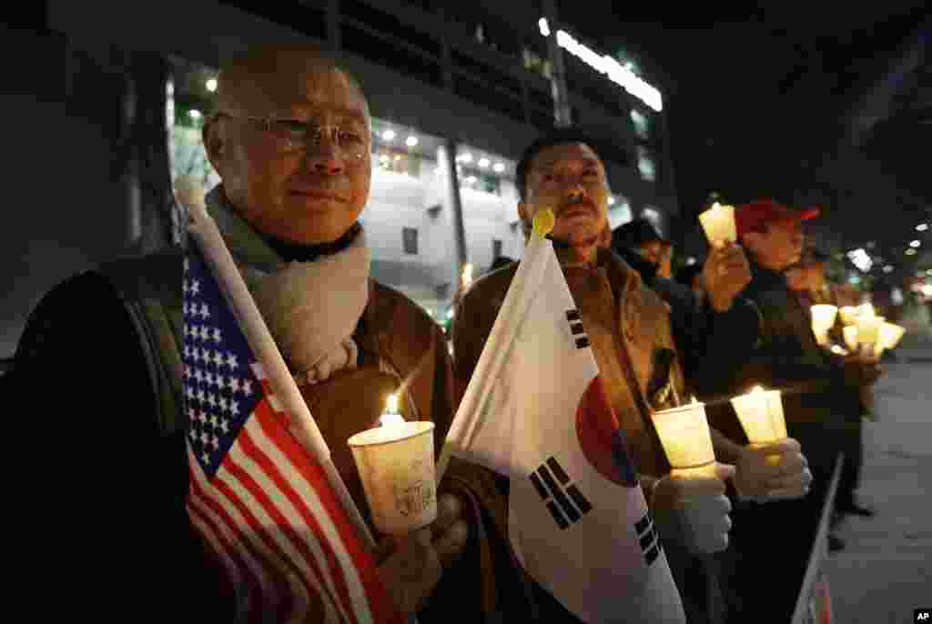 Aktivis konservatif Korea Selatan memegang lilin dalam sebuah aksi yang menyatakan simpati bagi Duta Besar AS untuk Korea Selatan Mark Lippert yang ditikam di Seoul. Polisi Korea Selatan tengah menyelidiki motif di balik aksi penikaman yang dilakukan oleh seorang aktivis anti-AS.