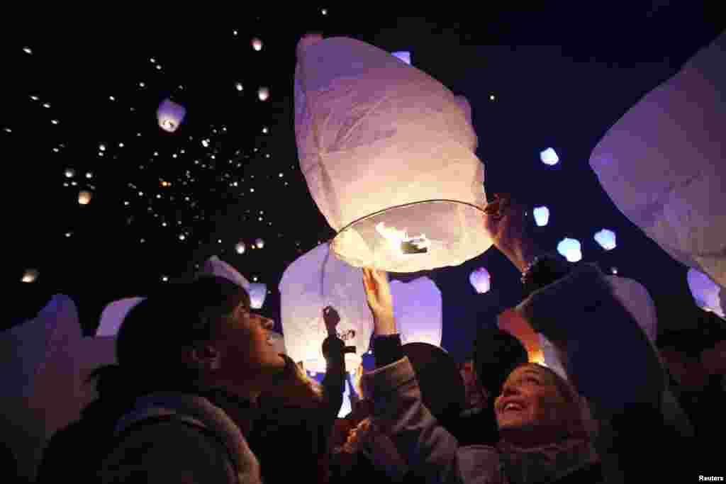 A participant releases a sky lantern during the &quot;Kapulica &amp; Lanterns&quot; event in Zagreb, Croatia, Dec. 23, 2013. The event, organized by contemporary artist Kresimir Tadija Kapulica as part of the ArtOmat Fair ahead of Christmas, involves people releasing about 1,000 lanterns to symbolize sending wishes to the universe.