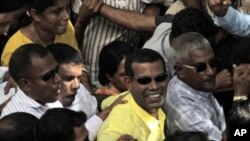 星期二刚刚辞去马尔代夫总统职务的纳希德(中)2月8日在首都马累和支持者一起参加集会