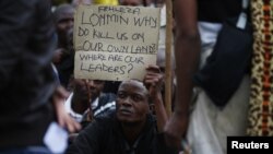 A mine worker holds up a sign during a march at Lonmin's Marikana mine in South Africa's North West Province, September 5, 2012. 