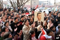 Pro-Syrian regime protesters in the flashpoint city of Homs in central Syria, Thursday, Dec. 29, 2011