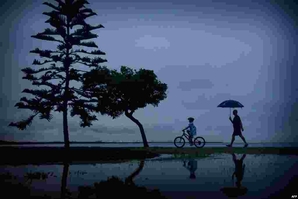 Residents make their way through rain from Tropical Cyclone Marcia in downtown Brisbane. Two powerful cyclones further north pounded Australia and left a trail of destruction with houses ripped apart, trees uprooted and power lines torn down, cutting electricity to thousands of people.