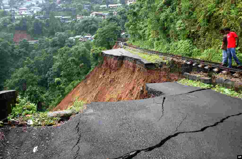 September 28: People stand on a highway damaged by a 6.9 magnitude earthquake near Siliguri, India. (AP Photo/Saptarshi Maitra)