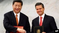 ທ່ານ Xi Jinping (ຊ້າຍ) ປະທານປະເທດຈີນ
ຈັບມືກັບທ່ານ Enrique Pena Nieto ປະທານາທິນາ Mexico ກ່ອນຈະເຂົ້າຮ່ວມກອງປະຊຸມຖະແຫລງຂ່າວຮ່ວມກັນ ຫລັງພິທີ ເຊັນສັນຍາຮ່ວມມືກັນ ທີ່ທໍານຽບປະທານາທິບໍດີ Los Pinos ໃນ Mexico City ໃນວັນອັງຄານ ທີ 4 ມິຖຸນາ 2013. 