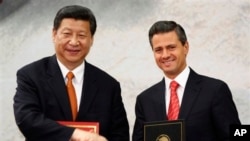 Presiden China Xi Jinping (kiri) dan Presiden Meksiko Enrique Pena Nieto berjabat tangan seusai penandatanganan perjanjian kerjasama bilateral China-Meksiko di rumah kediaman presiden di Los Pinos, Meksiko (4/6).
