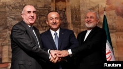 Turkish Foreign Minister Mevlut Cavusoglu, center, poses with his counterparts Elmar Mammadyarov, left, of Azerbaijan and Javad Zarif of Iran following a news conference in Istanbul, Turkey, Oct. 30, 2018.