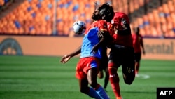 DR Congo's forward Cedric Bakambu (L) fights for the ball with Uganda's defender Hassan Wasswa during the 2019 Africa Cup of Nations (CAN) football match between DR Congo and Uganda at Cairo International Stadium on June 22, 2019. (Photo by JAVIER...