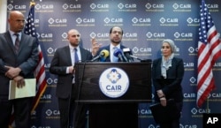 Attorneys Shereef Akeel, left, Gadeir Abbas, and Lena Masri, right, stand as Council on American-Islamic Relations (CAIR) national executive director Nihad Awad speaks during a news conference in Washington, Jan. 30, 2017.