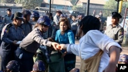 Seorang mahasiswa peserta aksi protes (kanan depan) membagikan makanan mereka kepada polisi sambil meneruskan aksi duduk mereka di Letpadan, sebelah utara Rangoon, Myanmar (4/3).