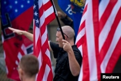 FILE - A member of a white supremacy group gives a fascist salute during a gathering in West Allis, Wisconsin, Sept. 3, 2011.