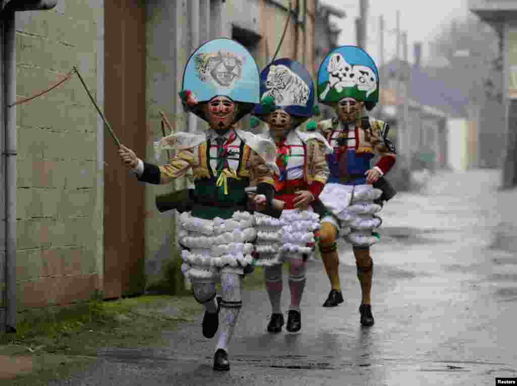 Carnival revelers dressed as &quot;Peliqueiros&quot; run along a street in the village of Laza, Spain.