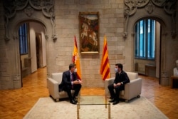 FILE - Spanish Prime Minister Pedro Sanchez and Catalonian regional president Pere Aragonès, right, talk at the headquarter of the Government of Catalonia in Barcelona, Sept. 15, 2021.