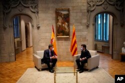 FILE - Spanish Prime Minister Pedro Sanchez and Catalonian regional president Pere Aragonès, right, talk at the headquarter of the Government of Catalonia in Barcelona, Sept. 15, 2021.