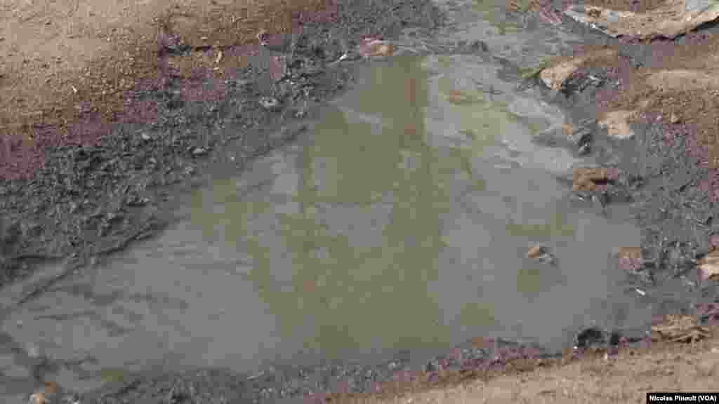 Dirty water is seen in puddles at the New Kuchogoro camp in Abuja, Nigeria, March 7, 2016. (N. Pinault / VOA) &nbsp;