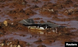 FILE - Debris of a house is shown at Bento Rodrigues district, which was covered with mud after a dam owned by Vale SA and BHP Billiton Ltd burst in Mariana, Brazil, Nov. 6, 2015.