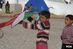 Children in camp pass time playing with kites given to them by Kurdish peshmerga soldiers in Hassan Shams, Kurdish Iraq, Jan. 10, 2017. (H. Murdock/VOA)