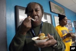 Billie Pollard, left, and Robert Howard try the cassoulet from the Sanford Restaurant at the Guest House, a Milwaukee homeless shelter, Dec. 8, 2015.