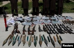 FILE - Weapons and ammunition seized are presented to the media along with insurgents suspected of being from the Haqqani network at the National Directorate of Security (NDS) headquarters in Kabul, May 30, 2013.