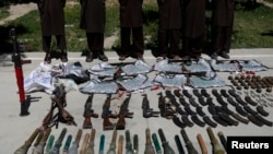FILE - Weapons and ammunition seized are presented to the media along with insurgents suspected of being from the Haqqani network at the National Directorate of Security (NDS) headquarters in Kabul, May 30, 2013.