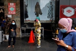 Women wearing protective masks following the outbreak of the coronavirus disease (COVID-19) stand outside a shopping mall at Tanah Abang textile market in Jakarta, Indonesia, November 23, 2020. REUTERS/Willy Kurniawan