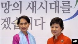 Pemimpin oposisi Burma, Aung San Suu Kyi (kiri) berjabat tangan dengan Presiden terpilih Korea Selatan, Park Geun-hye di Seoul, Korea Selatan, 29 Januari 2013 (AP Photo/Jung Yeon-je, pool).