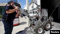 Tehničar policijskog odreda za demontiranje bombi iz Klivelnda utovaruje robotsko vozilo tipa Remotec F5A posle demonstracije policijskim mogućnosti u blizini mesta, gde će sutra početi Republikanska nacionalna konvencija