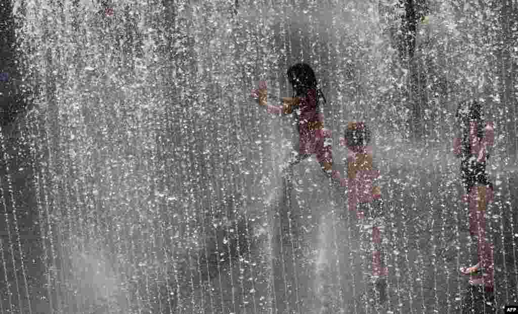 Children play in a water fountain in central London.