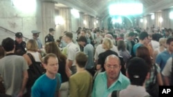 In this image made with a mobile phone camera, people leave a subway station in Moscow Wednesday, June 5, 2013. A rush-hour fire in Moscow’s subway injured dozens of people, forced the evacuation of thousands of commuters.