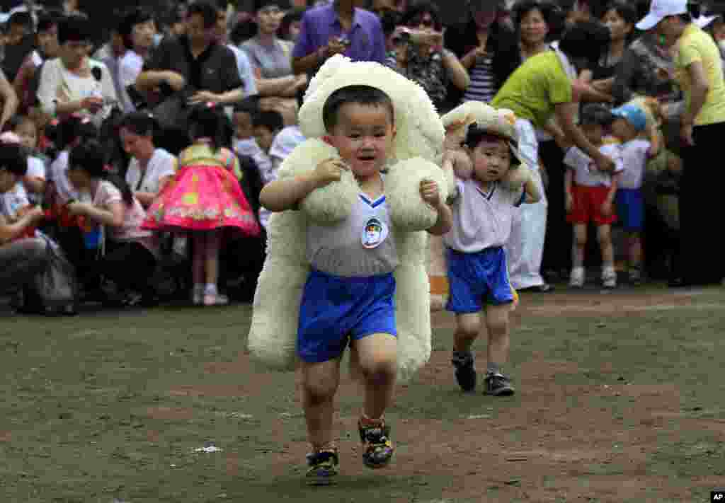 &#39;국제아동절&#39;인 1일 북한 평양의 &#39;9.15 보육원&#39;에서 열린 운동회에서 어린이들이 커다란 인형을 등에 엎고 달리고 있다.