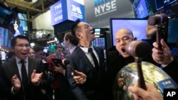 Tao Sang Tong (C), Chairman of Tencent Music Entertainment, and Co-President Guomin Xie (R) strike the bell at the New York Stock Exchange to mark the Chinese company's IPO, Dec. 12, 2018. 