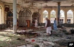 FILE: People inspect the inside of a mosque following a bombing in Kunduz province northern Afghanistan, Oct. 8, 2021.