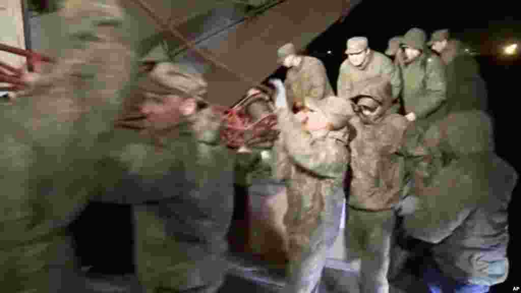 Des soldats russes tranportent des munitions dans un avion militaire à Hemeimeem sur une base aérienne en Syrie, le 15 mars 2016.