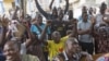 Supporters of presidential candidate Muhammadu Buhari cheer as they watch news coverage of election results favourable to them on a street in Lagos, March 31, 2015. The opposition All Progressives Congress (APC) declared victory for its candidate, former 