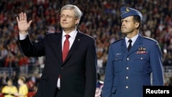 Perdana Menteri Kanada Stephen Harper (kiri) dan Kepala Staf Umum Pertahanan Kanada Tom Lawson ikut dalam sebuah tribute untuk tentara Kanada yang tewas tertembak, sebelum pertandingan football CFL antara Ottawa Redblacks dan Montreal Alouettes di Ottawa.