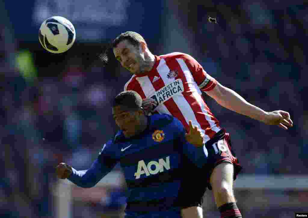 Sunderland's John O'Shea (R) challenges Manchester United's Antonio Valencia during their English Premier League soccer match in Sunderland, northern England.