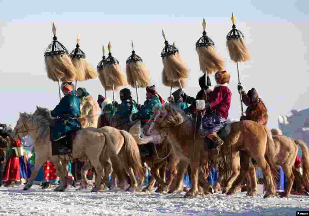 Participants in traditional Mongolian costumes ride horses at the opening ceremony of a winter Naadam fair in Hulunbuir, Inner Mongolia, China, Dec. 23, 2018.